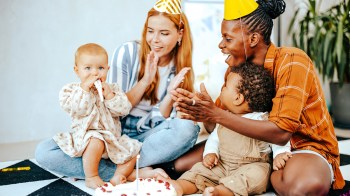 相片两个妈妈和两个婴儿拍手 可爱第一生日派对思想
