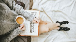 一个女人读书 带一杯咖啡和袜子
